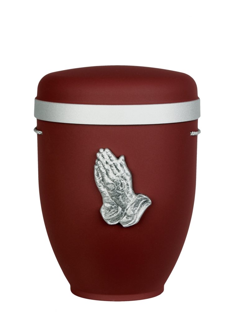 Naturfaserurne, matt weinrot, Silberrand breit mit aufgesetztem Emblem „Dekor-Emblem bet. Hände“ in Silber