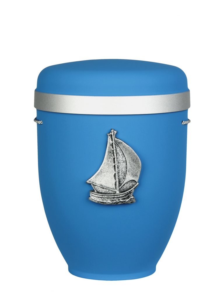 Naturfaserurne, matt hellblau, Silberrand breit mit aufgesetztem Emblem „Dekor-Emblem Segelschiff“ in Silber