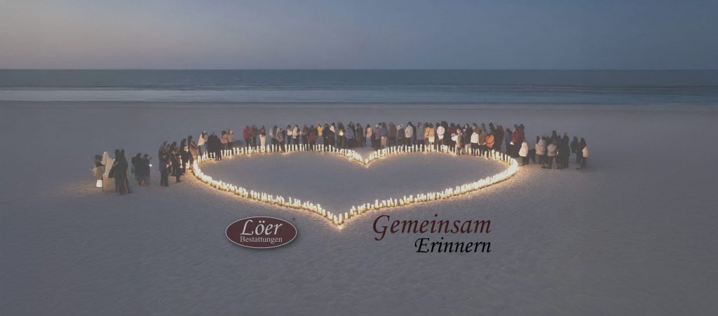 Menschen versammeln sich im Kerzenherz am Strand – Symbol für Erinnerung und Gemeinschaft auf den Gedenkseiten von Löer Bestattungen