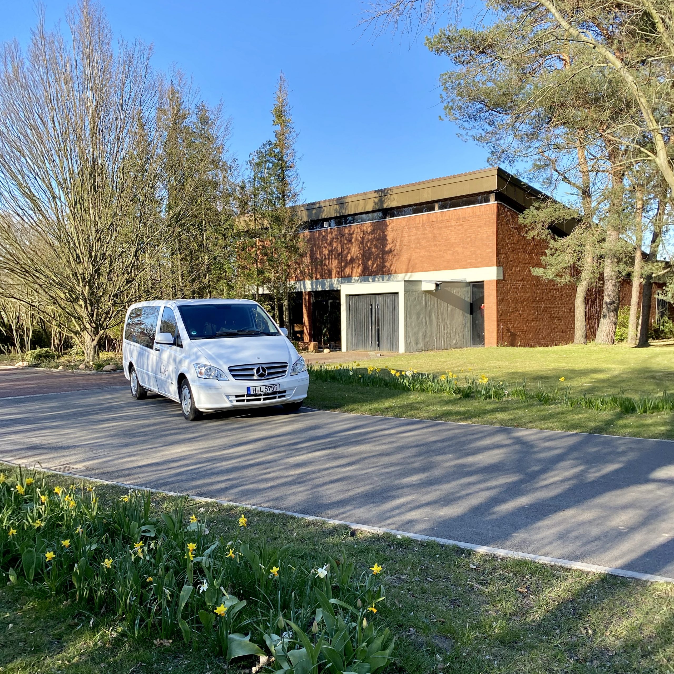 Weißer Bestattungswagen von Löer Bestattungen vor der Kapelle auf dem Zentralfriedhof „Im Heidfeld“ in Laatzen