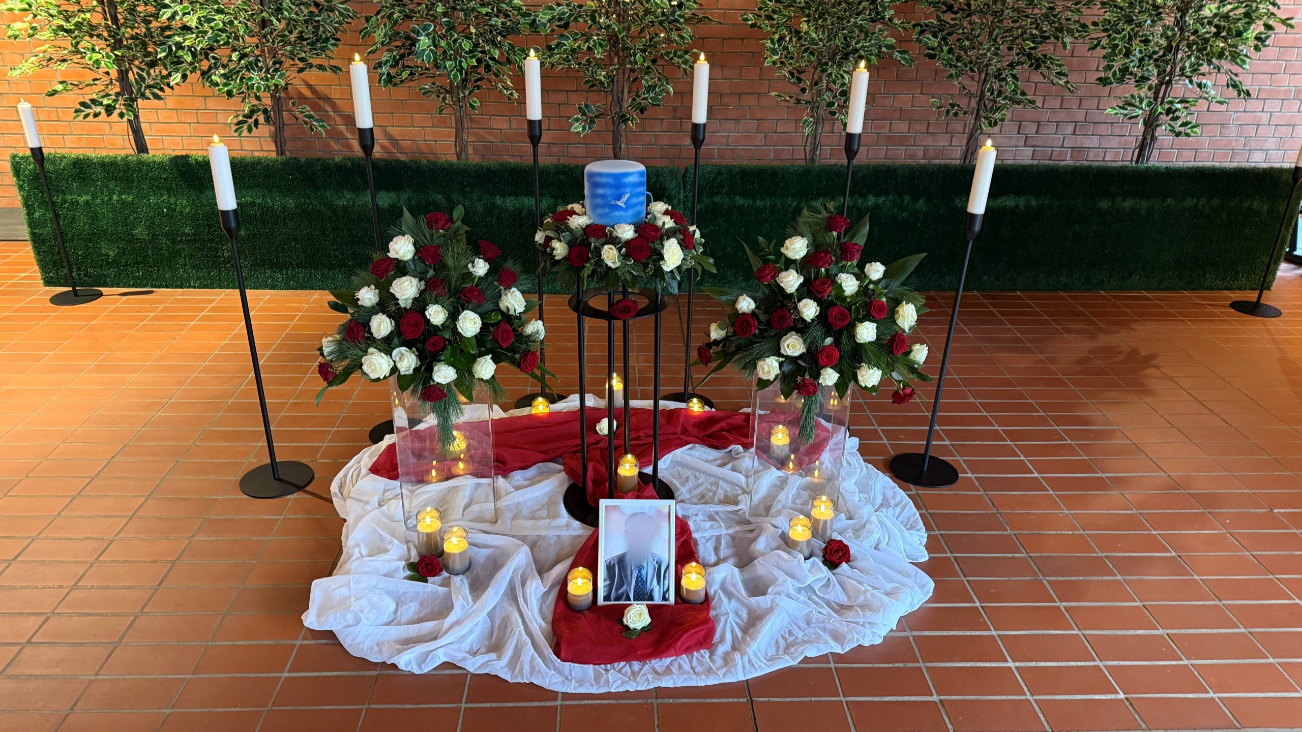 Urnenaufbahrung mit Blumenschmuck, Kerzen und Portrait bei einer Feuerbestattung in Laatzen